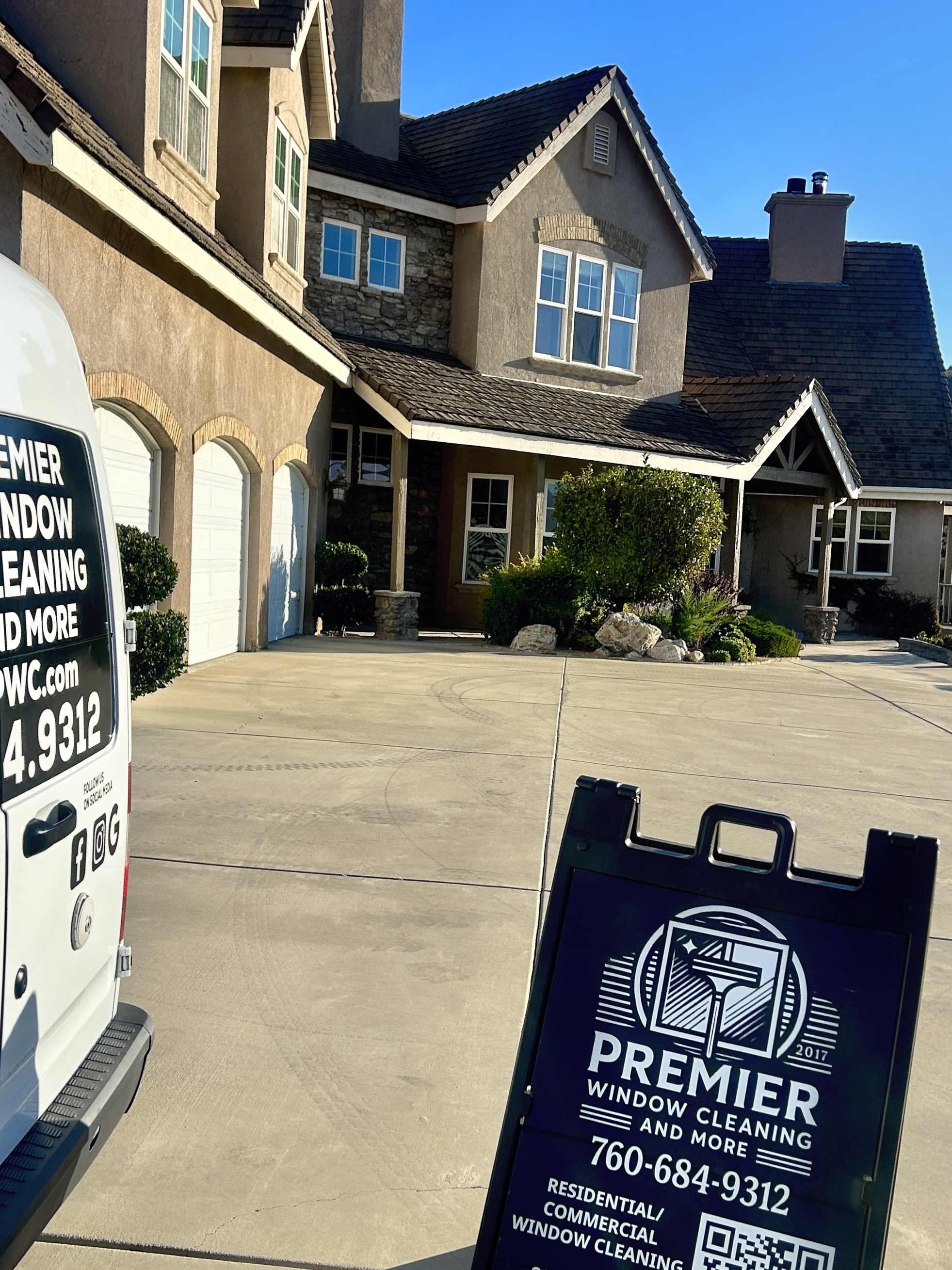 Premier service van and sign outside a two-story home